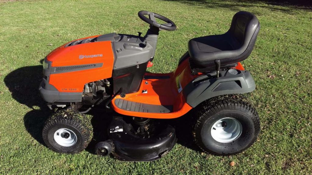 Tractor cortacésped segando una pradera