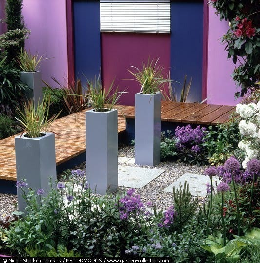 Jardín contemporáneo con superficies drenantes y masas de vivaces